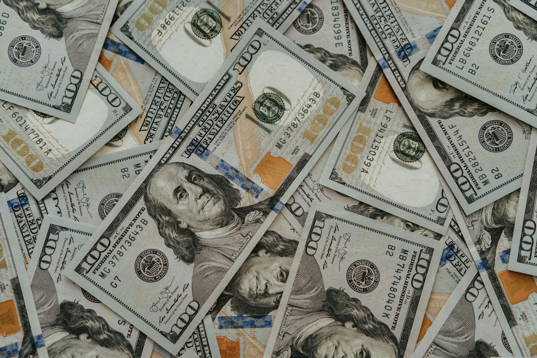 Close-up of American 100 dollar bills scattered, highlighting wealth and currency concepts.